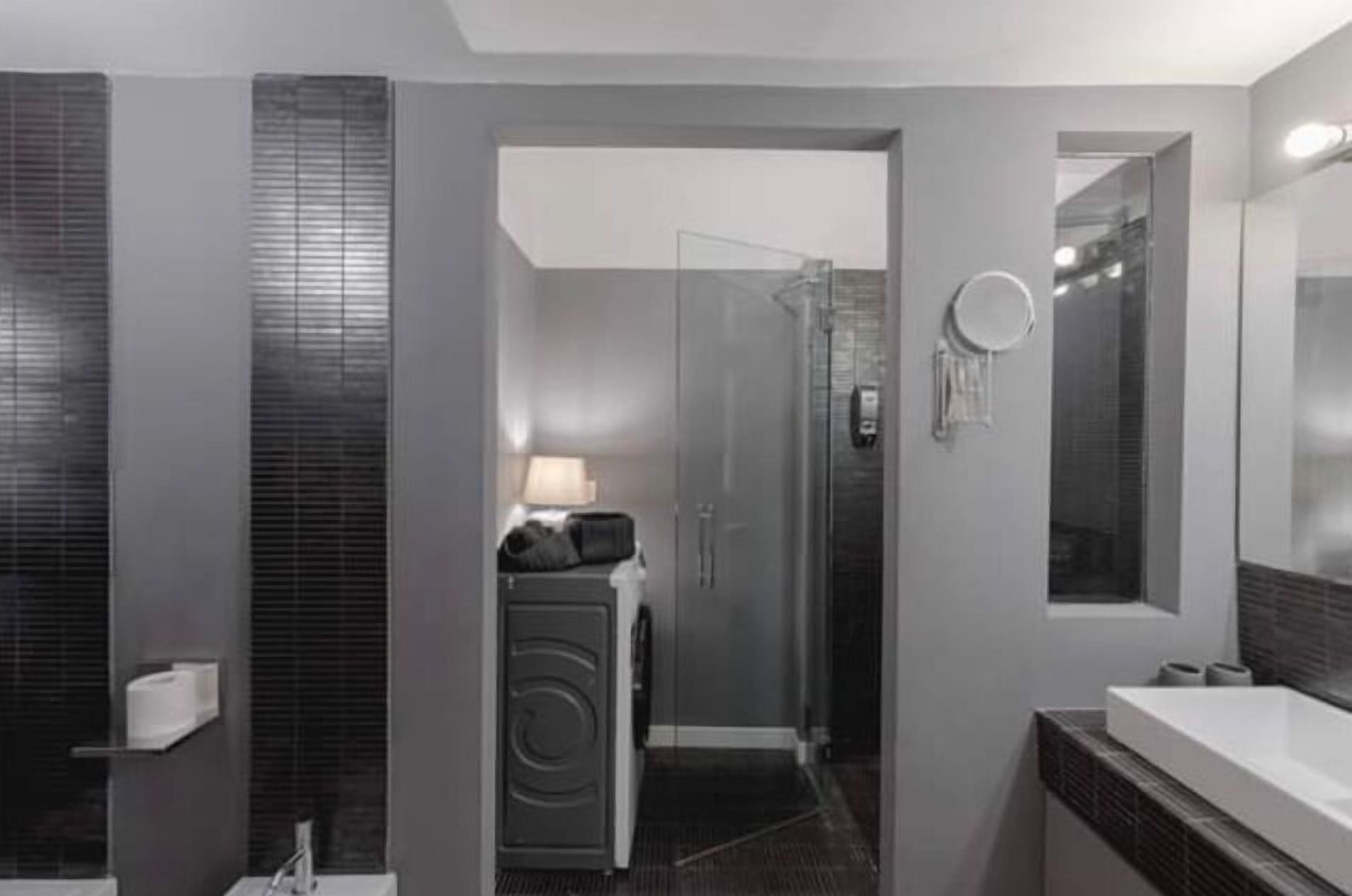 A modern bathroom with a walk-in shower, a toilet, and a sink.