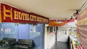 A hotel entrance with a glass door, a sofa inside, and a red and yellow sign above. - Hotel City Bukit Bintang (Kuala Lumpur)