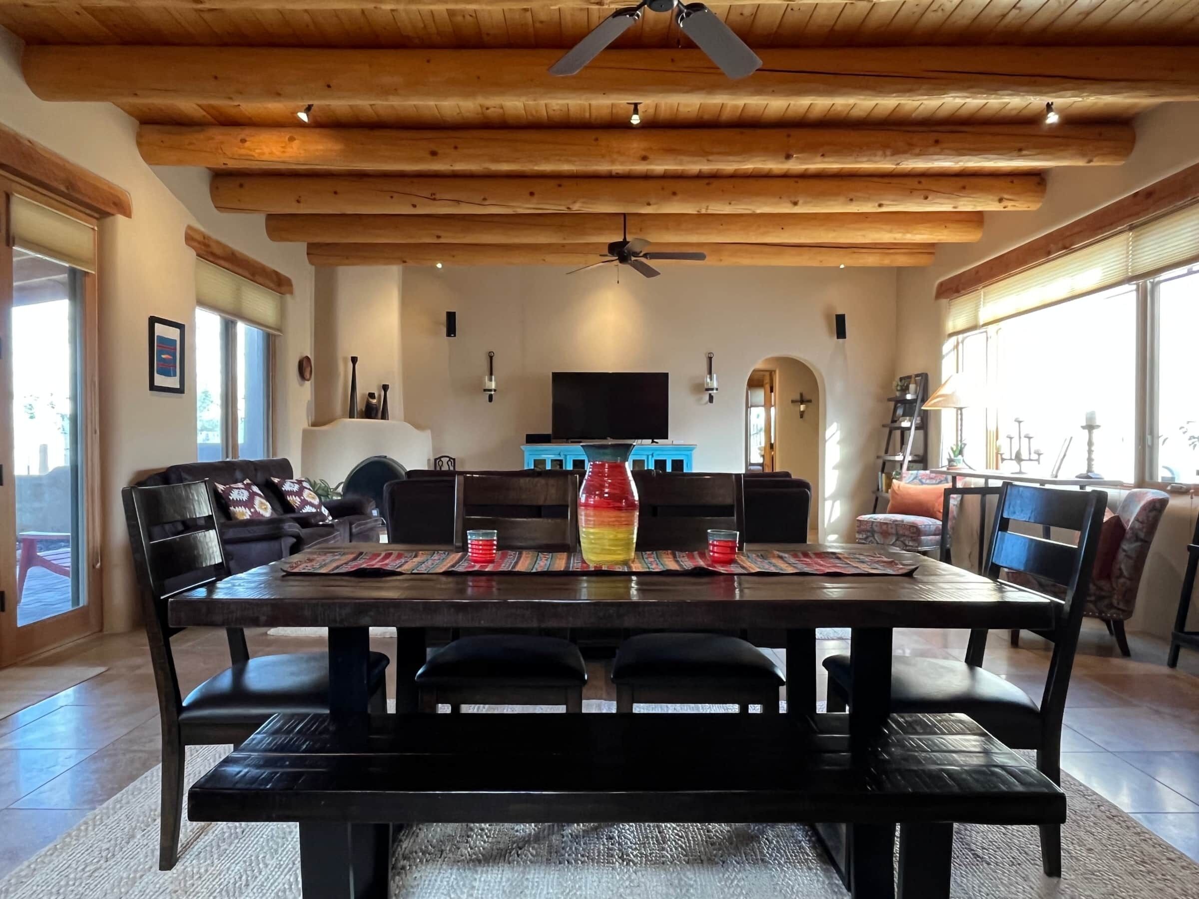 Un espace repas doté d’un plafond en bois, d’un ventilateur de plafond, d’un téléviseur et d’une grande fenêtre.