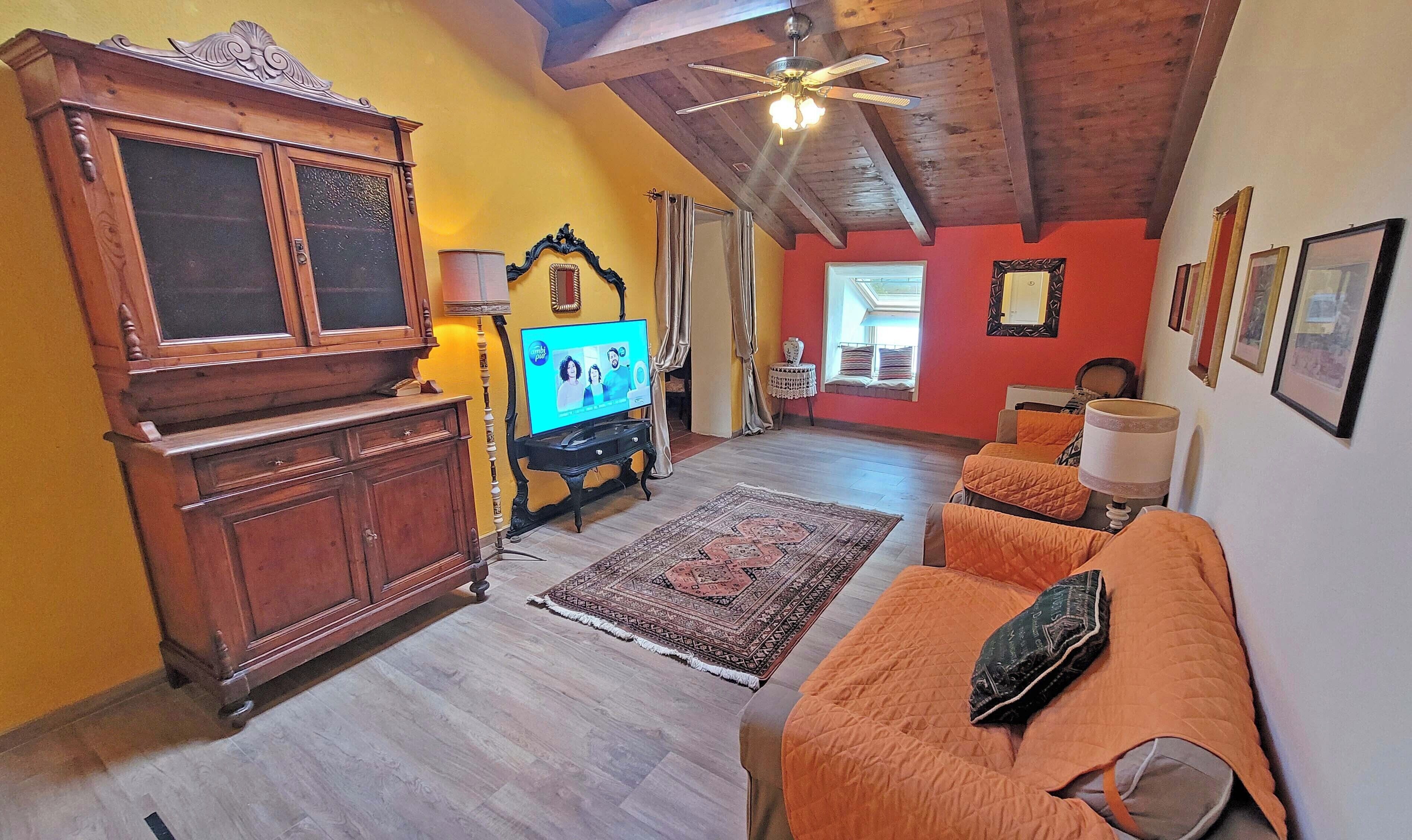 A cozy living room with a wooden cabinet, a television, and a sofa.