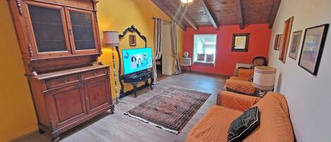 A cozy living room with a wooden cabinet, a television, and a sofa.