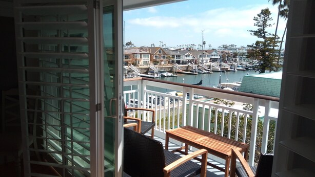 Un balcón con vistas a un puerto deportivo, con barcos y casas.