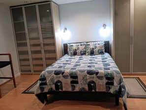 Une chambre à coucher avec un lit, une armoire et une chaise.