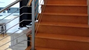 Una escalera con barandilla metálica que lleva a una plataforma.