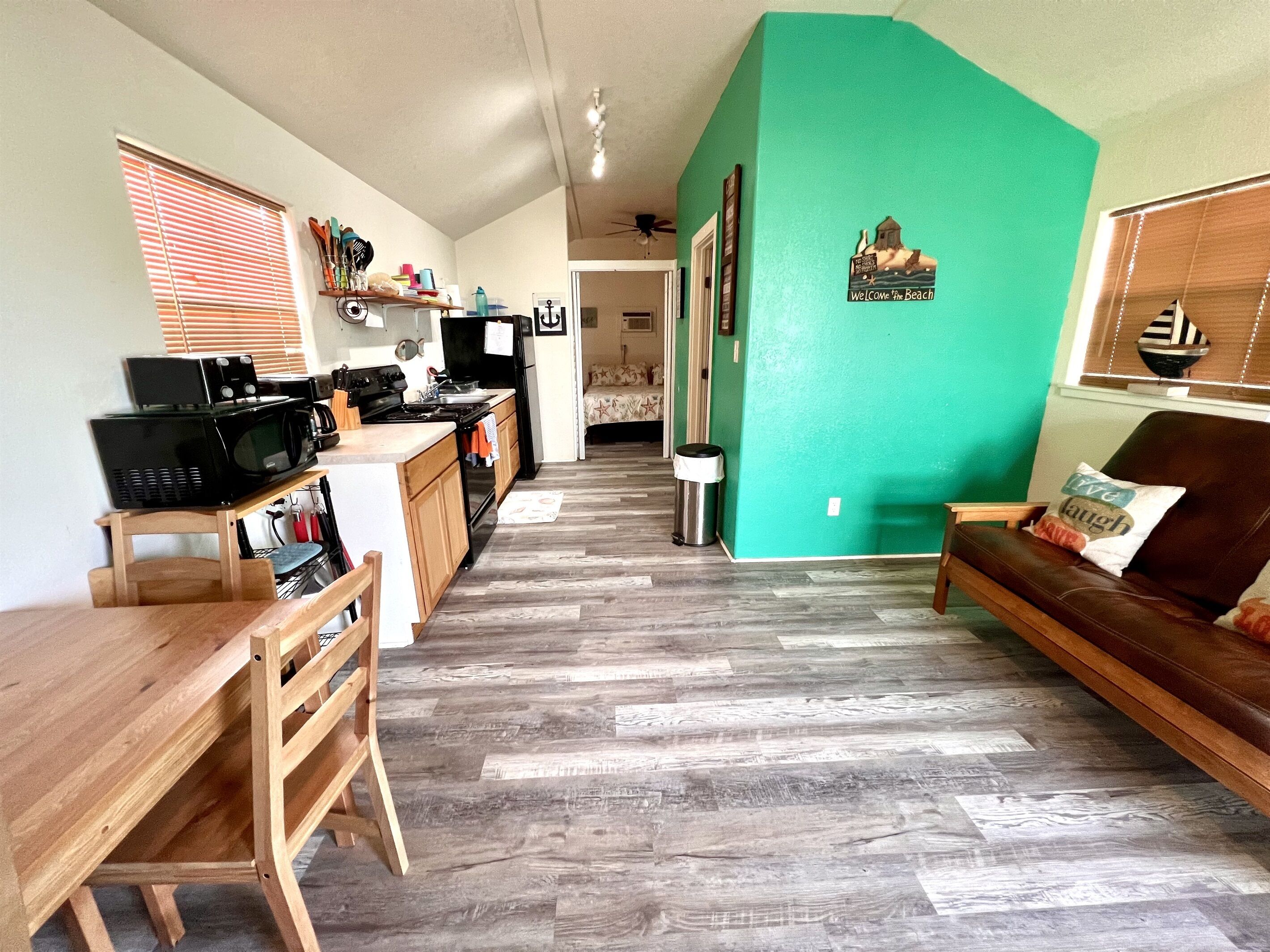 A spacious living area with a kitchen, a dining table, and a sofa.