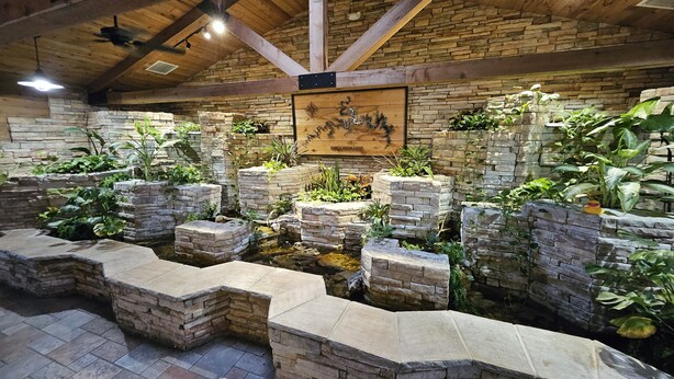 A stone fish pond with plants, a wooden ceiling, and a compass mural. - Family-Friendly Branson Condo w/ Outdoor Pool! (Branson)