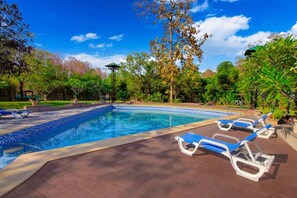 A swimming pool with lounge chairs and a gazebo.