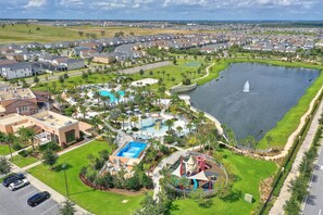 Zona residencial con una piscina grande, una fuente y un parque infantil.