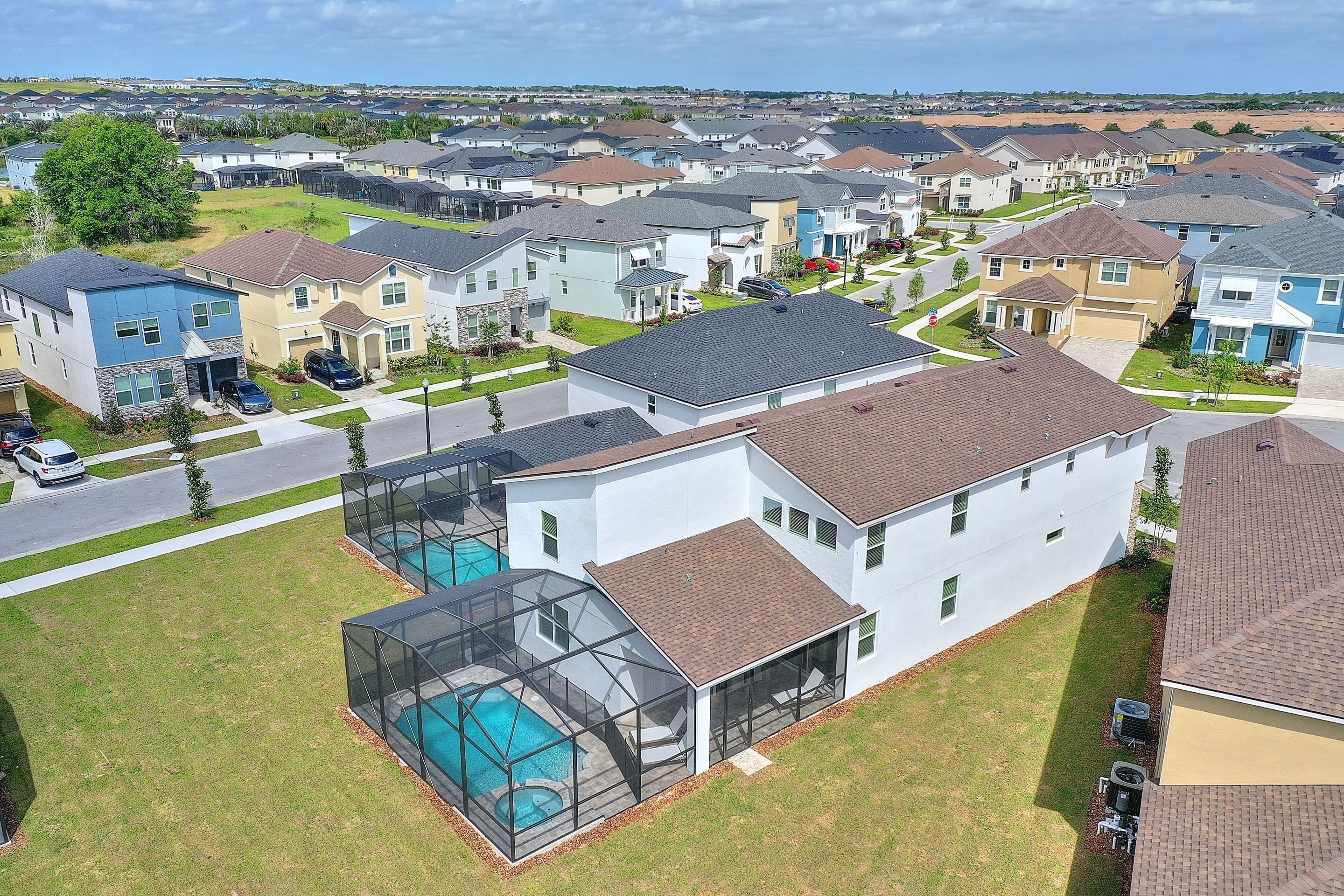 A residential area with modern houses, a swimming pool, and a well-maintained lawn.