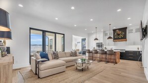 A modern living room with a sofa, coffee table, and a view of the outdoors.