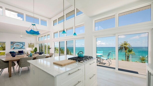 A spacious kitchen with a large island, multiple windows, and a view of the ocean. - Dream House 3 Bedroom Home (North Palmetto Point)