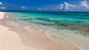 Ein Strand mit klarem türkisblauem Wasser und einem sandigen Ufer.