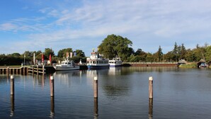 A calm river with boats docked at a pier, surrounded by trees and a clear sky. - Apartment Seestern Prerow/parking lot, 2 bicycles, bed linen/towels incl. (Prerow)