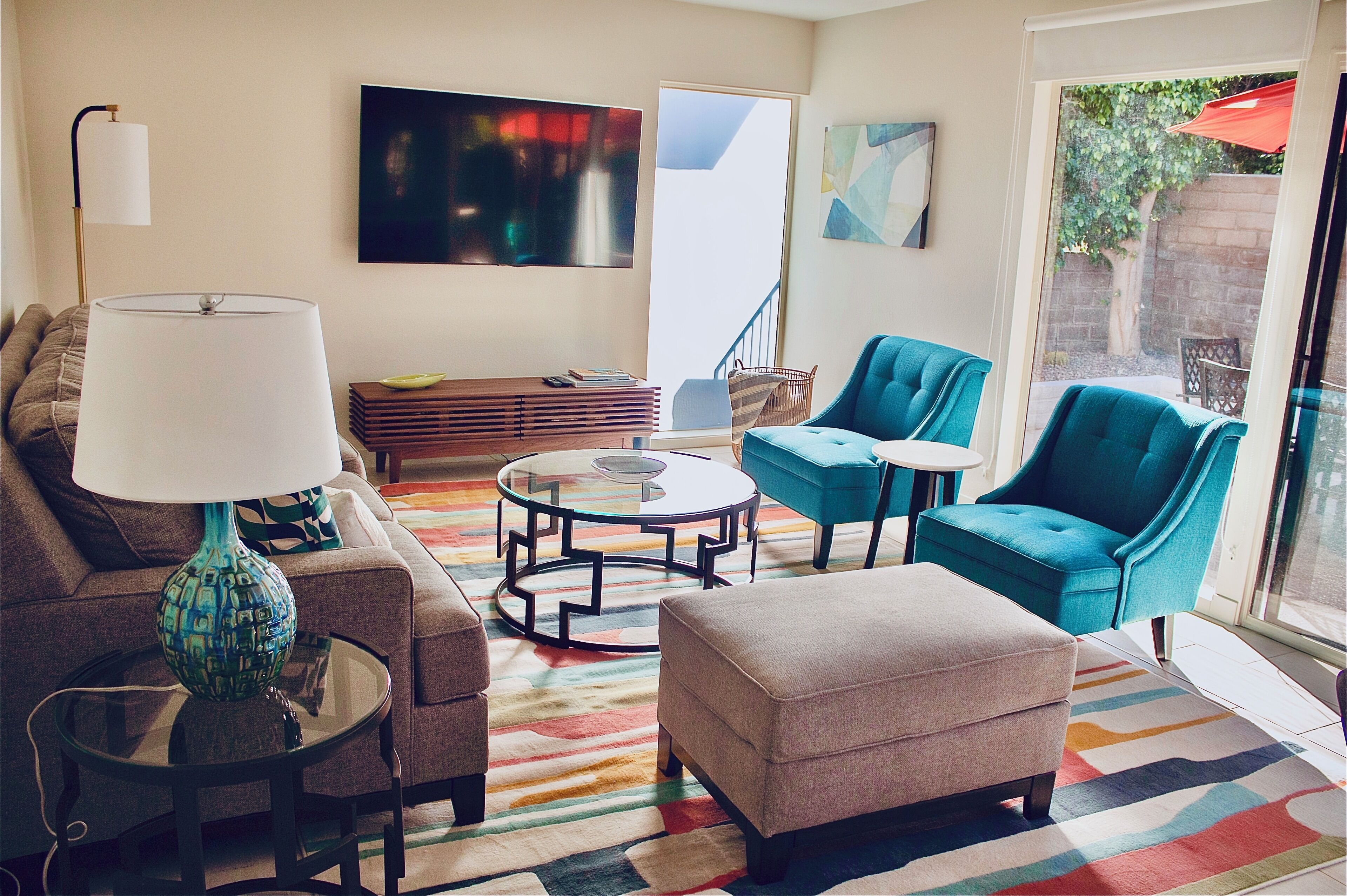 A living room with a sofa, ottoman, two armchairs, a coffee table, and a lamp.