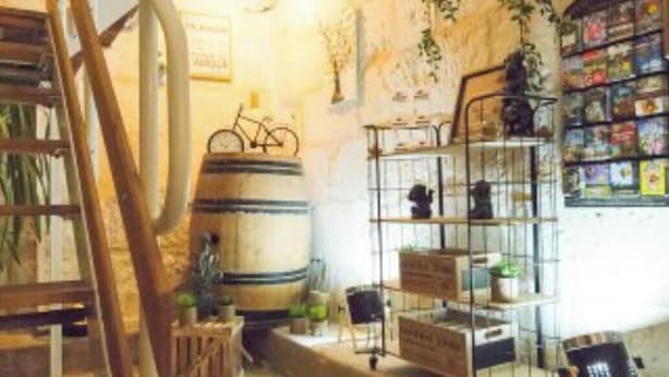 A rustic interior with a wooden staircase, metal shelves with plants, and a bookshelf. - Quiet, comfortable TORIS B&B (Neuil)