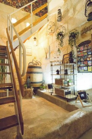 A rustic interior with a wooden staircase, metal shelves with plants, and a bookshelf. - Quiet, comfortable TORIS B&B (Neuil)