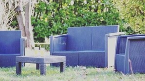 A seating area with blue woven furniture and a small table, surrounded by greenery. - Quiet, comfortable TORIS B&B (Neuil)