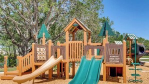 A playground with slides and climbing structures, surrounded by trees. - Beautiful Lake View House with 3/2 near Disney, Universal, Sea World and more! (Sparta)