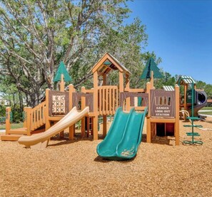A playground with slides and climbing structures, surrounded by trees. - Beautiful Lake View House with 3/2 near Disney, Universal, Sea World and more! (Sparta)