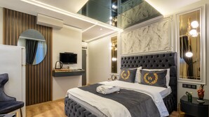 Une chambre moderne avec un grand lit, une télévision et un miroir.