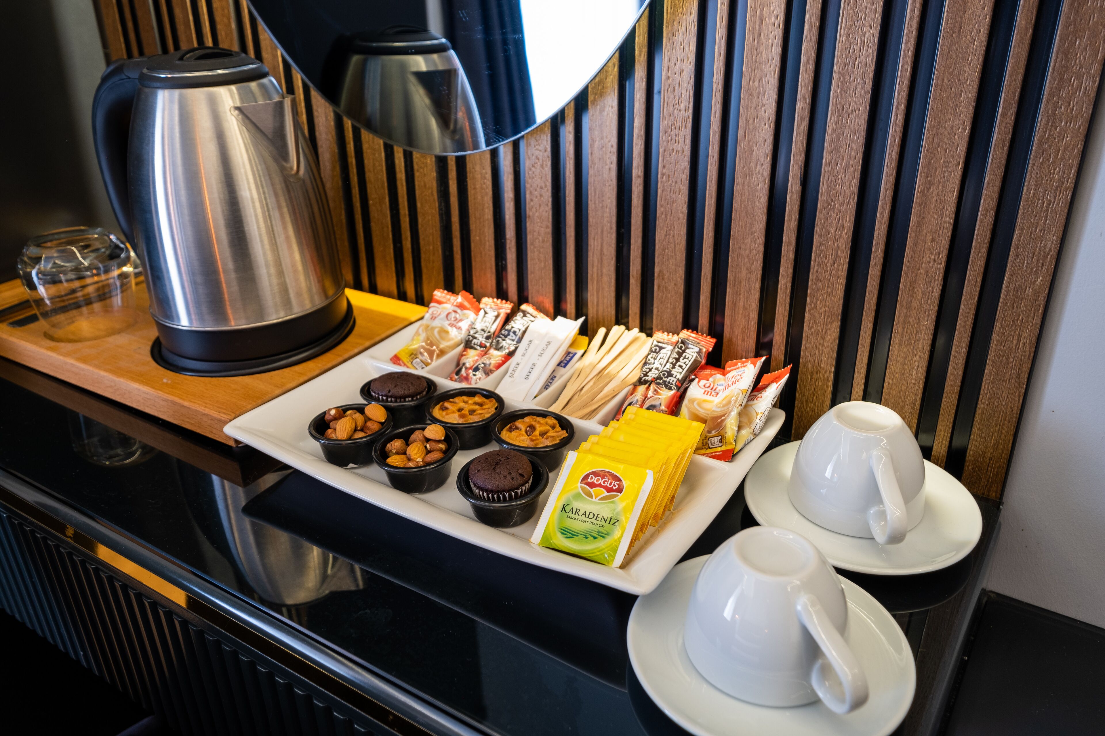 A breakfast tray with pastries, nuts, and a coffee pot.