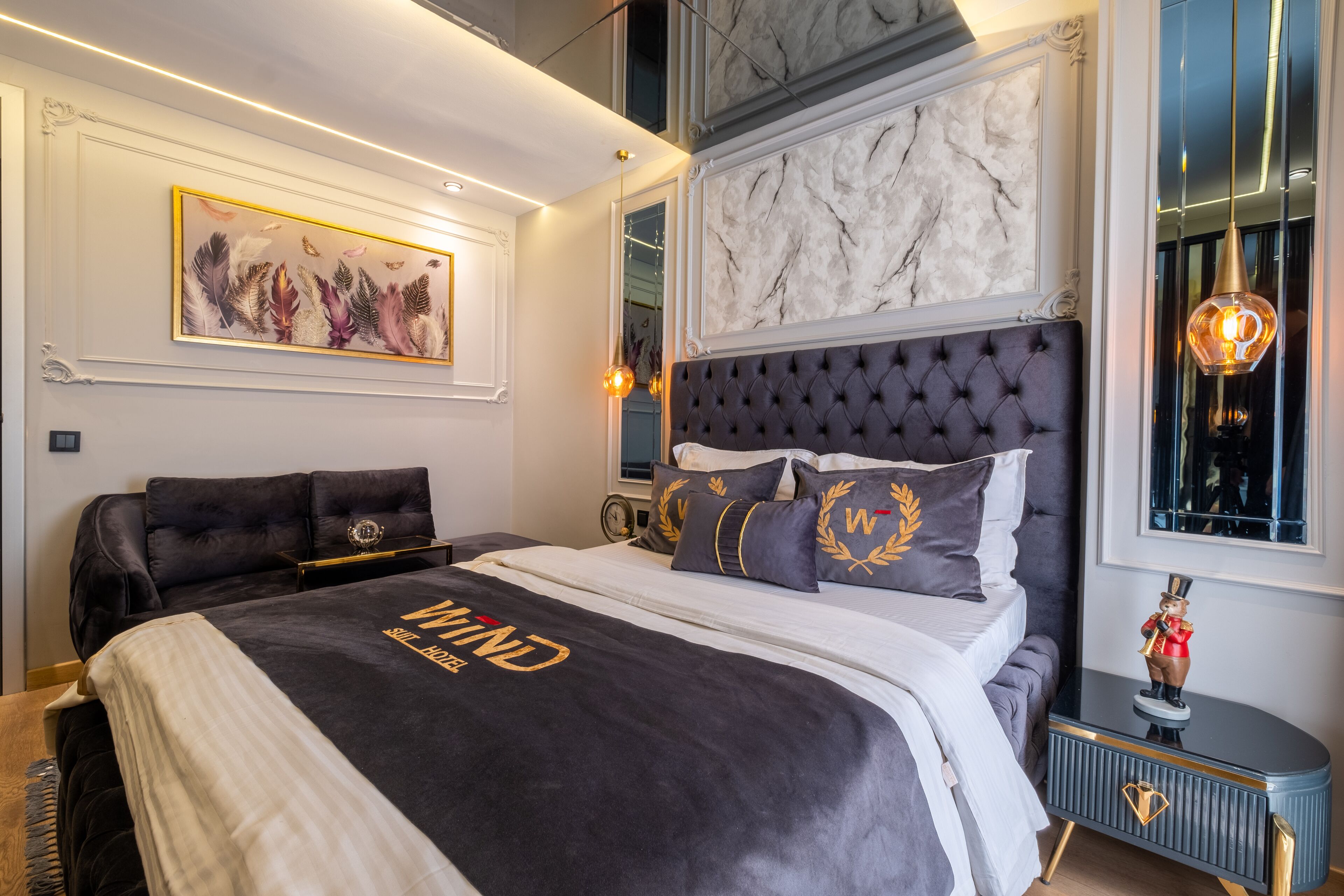 A modern bedroom with a large bed, a headboard with a marble-like texture, and a decorative wall piece.