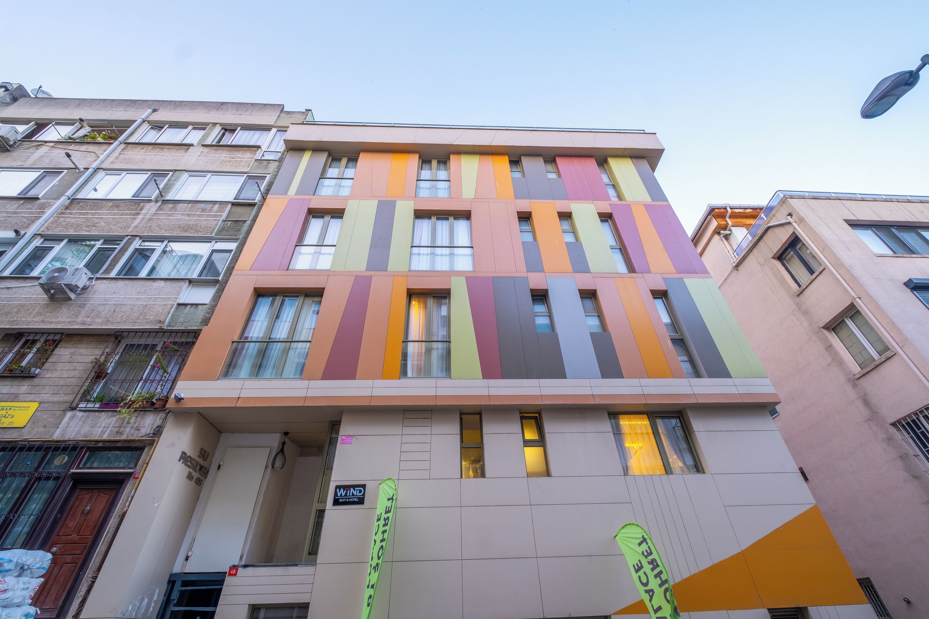 Un edificio de varios pisos con una fachada moderna, que presenta una combinación de tamaños de ventanas y un techo plano.