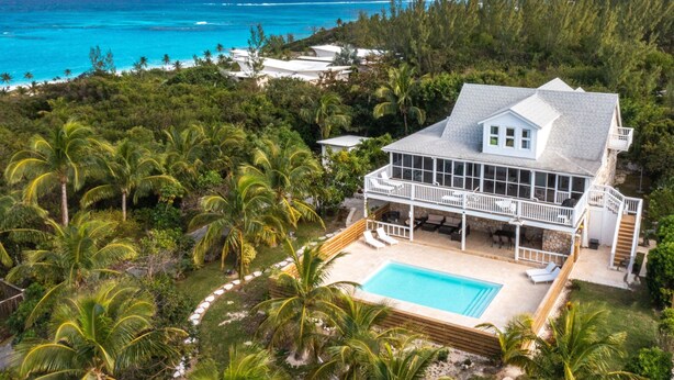 A large house with a pool, surrounded by palm trees and a view of the ocean. - Bahama Mama 5 Bedroom Home (Governor's Harbour)