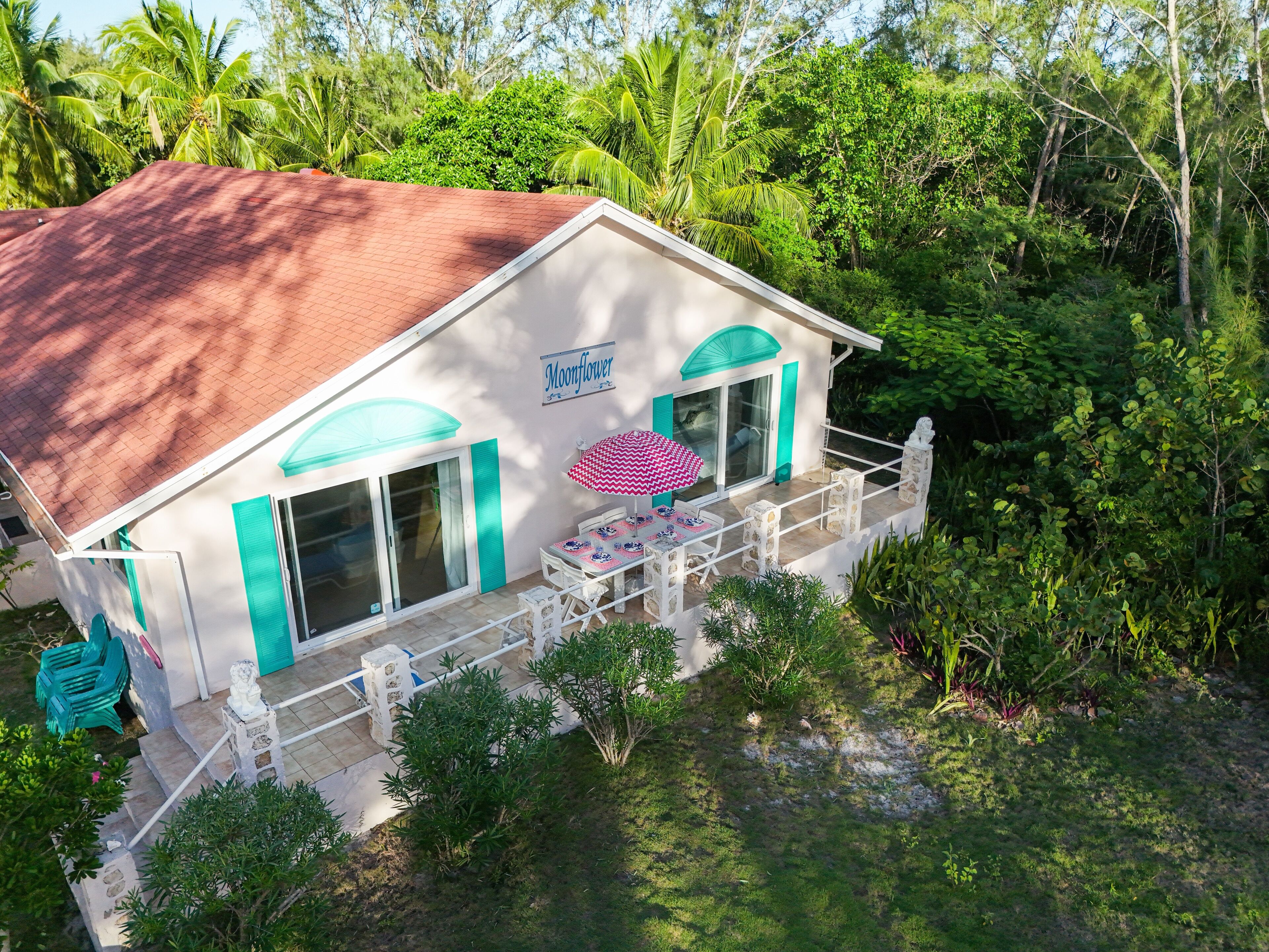 A house with a white exterior, turquoise accents, and a sign that reads "Moonflower."