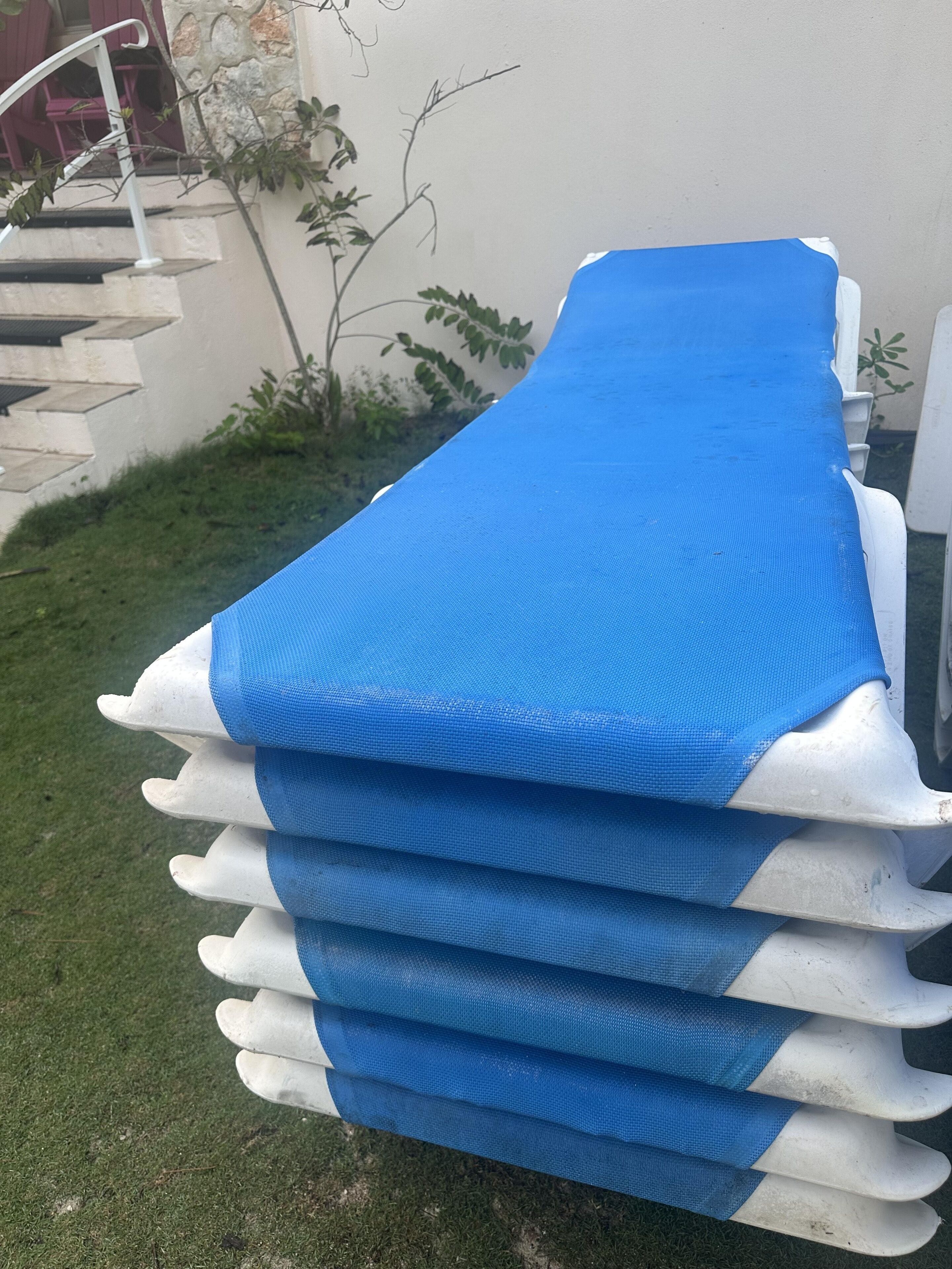 A stack of white pool floats with blue covers.