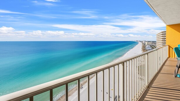 A balcony with a view of a beach and ocean.