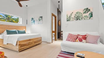 A modern bedroom with a wooden bed, a white sofa, and a large window.