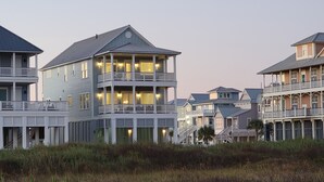 A coastal building with multiple balconies and a prominent central tower.