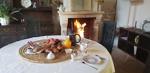 Ein Frühstückstisch für zwei Personen mit Croissants, Äpfeln und einer Kaffeekanne.
