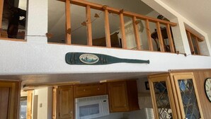 Cocina con armarios de madera, microondas y un toallero decorativo.