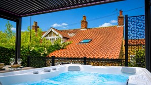 Ein Whirlpool mit Blick auf ein Haus mit Ziegeldach und Schornsteinen.