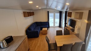 Un espacio habitable pequeño con sofá, mesa de comedor y televisor.