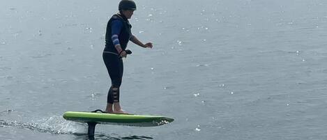 Una persona de pie sobre una tabla de surf en el agua.