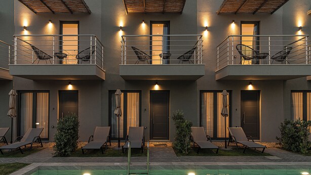 A modern building with a pool, multiple balconies, and outdoor seating areas. - NEK Suites - Adults Only (Chania)