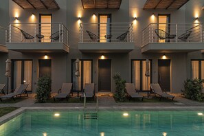 Ein modernes Gebäude mit Pool, mehreren Balkonen und Sitzbereichen im Freien.