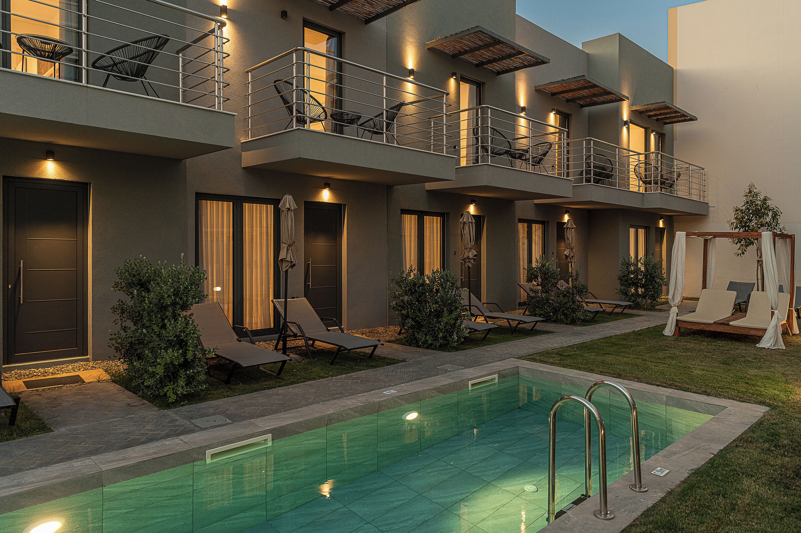 Un hôtel moderne doté d’une piscine, d’un espace extérieur aménagé et d’un balcon bien éclairé.