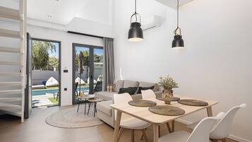 Um espaço moderno com área de jantar, sofá e vista para uma piscina ao ar livre.