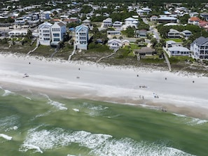A coastal residential area with beachfront properties, including multi-story houses with balconies and a sandy beach. - 5 Bed, 5 Bath Beach Home/only a 3 Minute Walk To The Beach! Sleeps 12 (Panama City Beach)