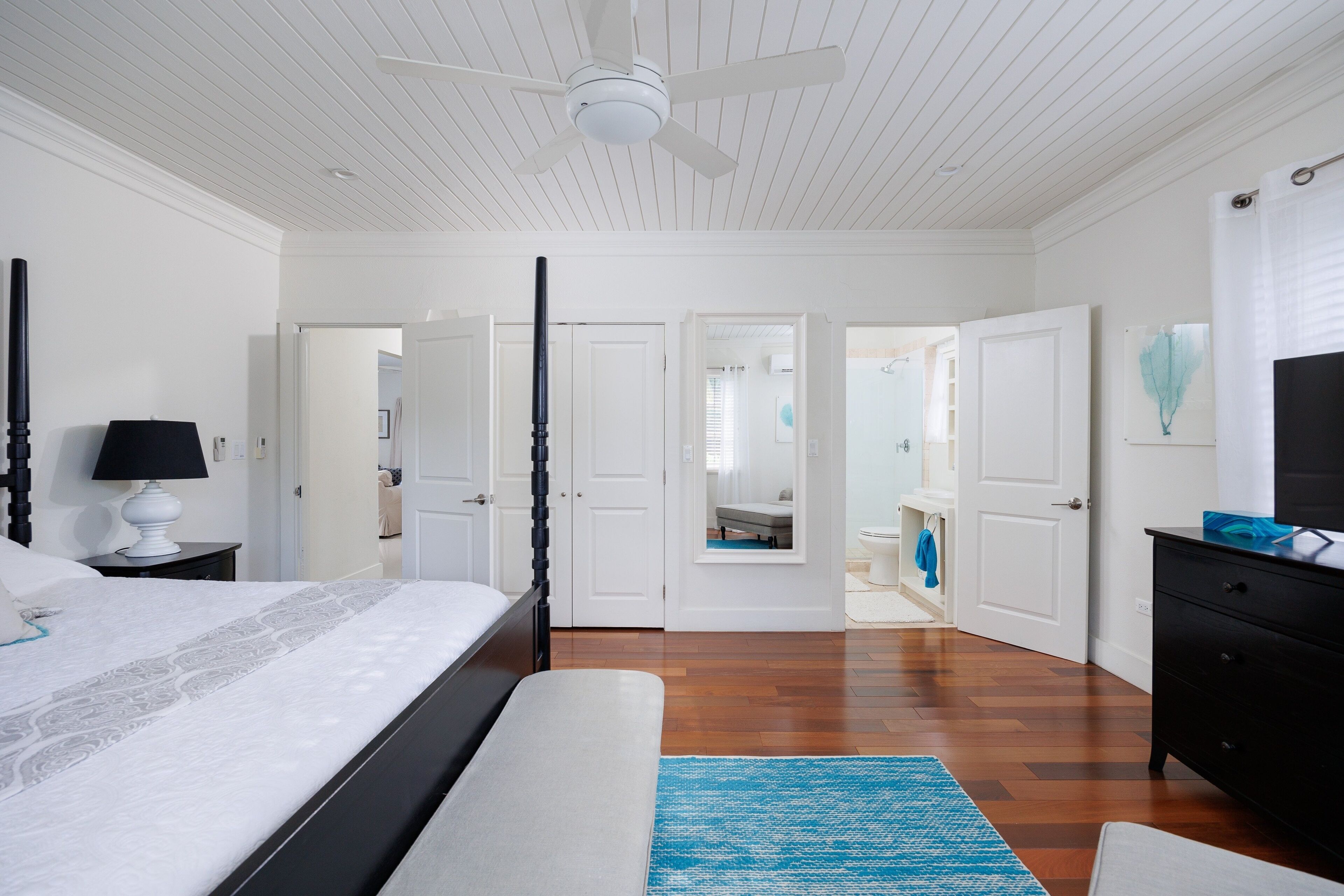 A bedroom with a bed, a nightstand, a dresser, and a ceiling fan.