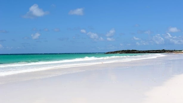 En strand med klart turkis vand og hvidt sand.