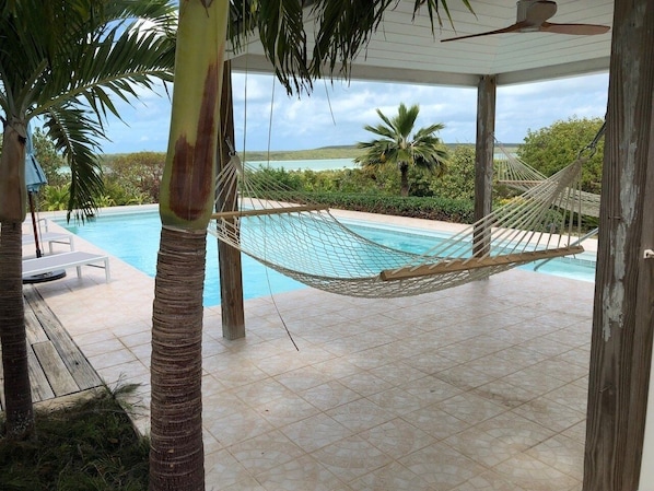 A hammock over a pool with a view of the landscape. - Utopia House 3 Bedroom Home (Savannah Sound)