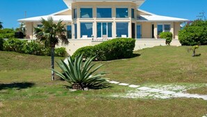 A large, modern house with a flat roof and multiple windows. - Endless Summer 5 Bedroom Home (Double Bay)
