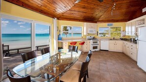 A kitchen with a view of the beach, wooden ceiling, and modern appliances. - Sand Dollar At Ten Bay Beach 4 Bedroom Home (South Palmetto Point)