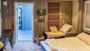 A cozy bedroom with a bed, a chair, a small table, and a door leading to a balcony. - Cozy home in Nissedal with house sea view (Nissedal)