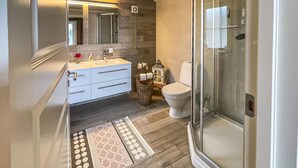 A modern bathroom with a glass shower enclosure, a white sink with a mirror above, and a toilet. - Cozy home in Nissedal with house sea view (Nissedal)
